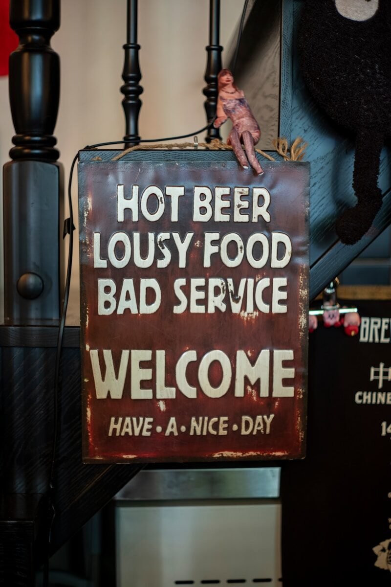 Rusty sign with humorous text about beer and food.