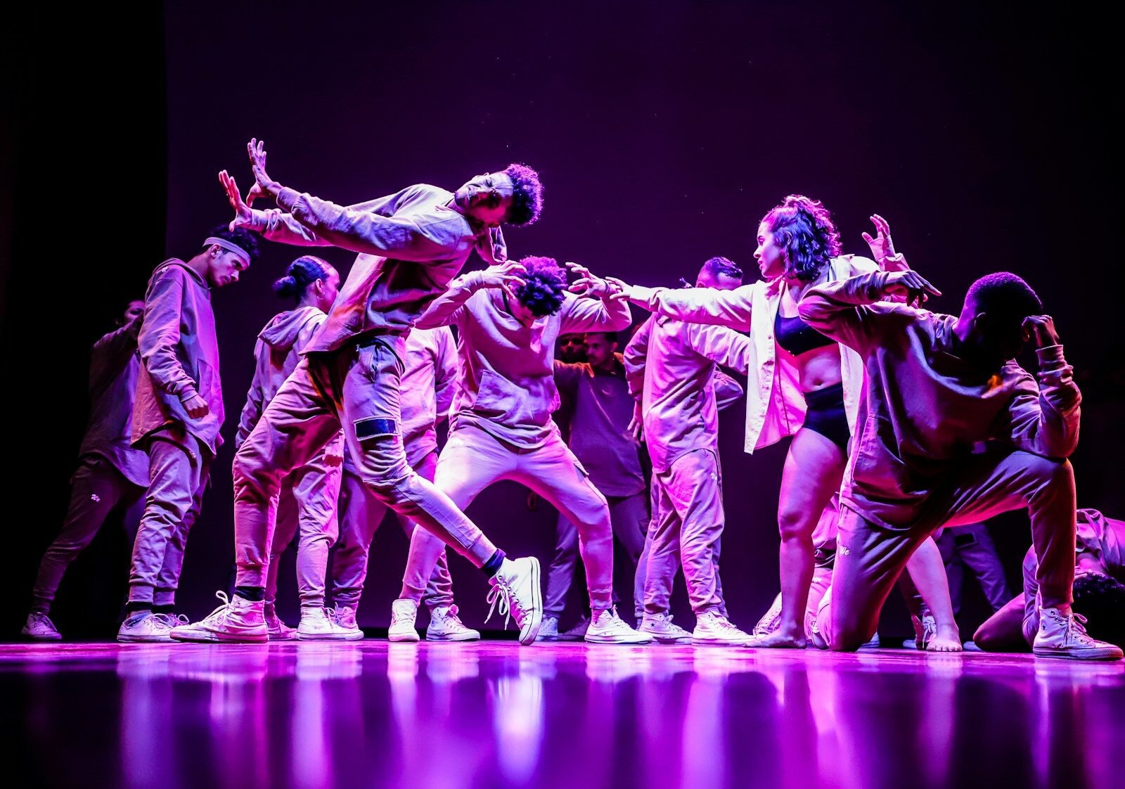 group of men in green and white shirts dancing on stage